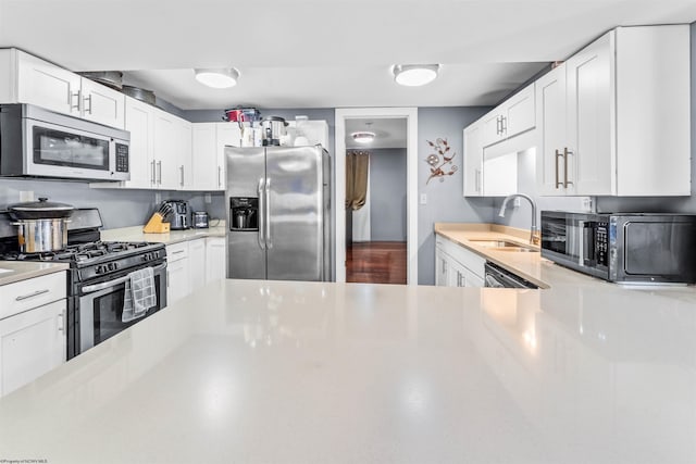 kitchen featuring white cabinets, stainless steel appliances, and sink