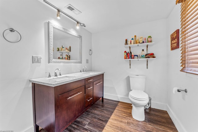 bathroom featuring toilet, vanity, and hardwood / wood-style flooring