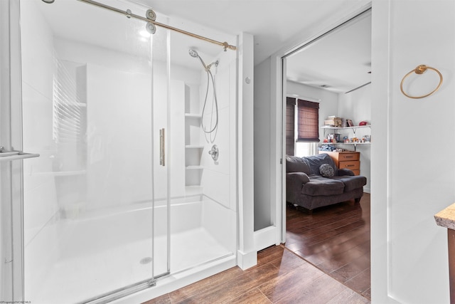 bathroom featuring wood-type flooring and a shower with shower door