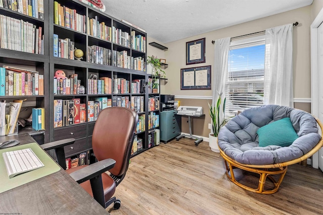 office area featuring light hardwood / wood-style floors and a textured ceiling