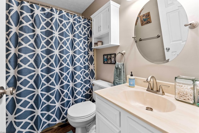 bathroom featuring vanity, toilet, and a textured ceiling