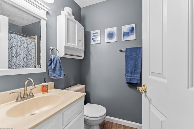 bathroom featuring hardwood / wood-style floors, vanity, a textured ceiling, and toilet