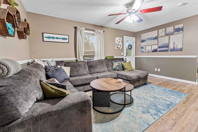 living room with hardwood / wood-style floors, ceiling fan, and a textured ceiling