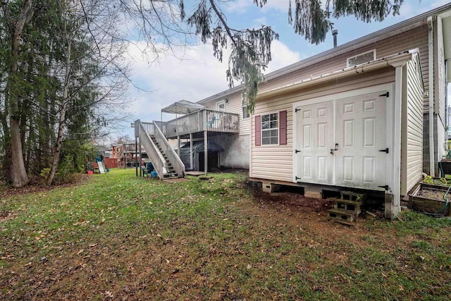 rear view of house with a yard and a wooden deck