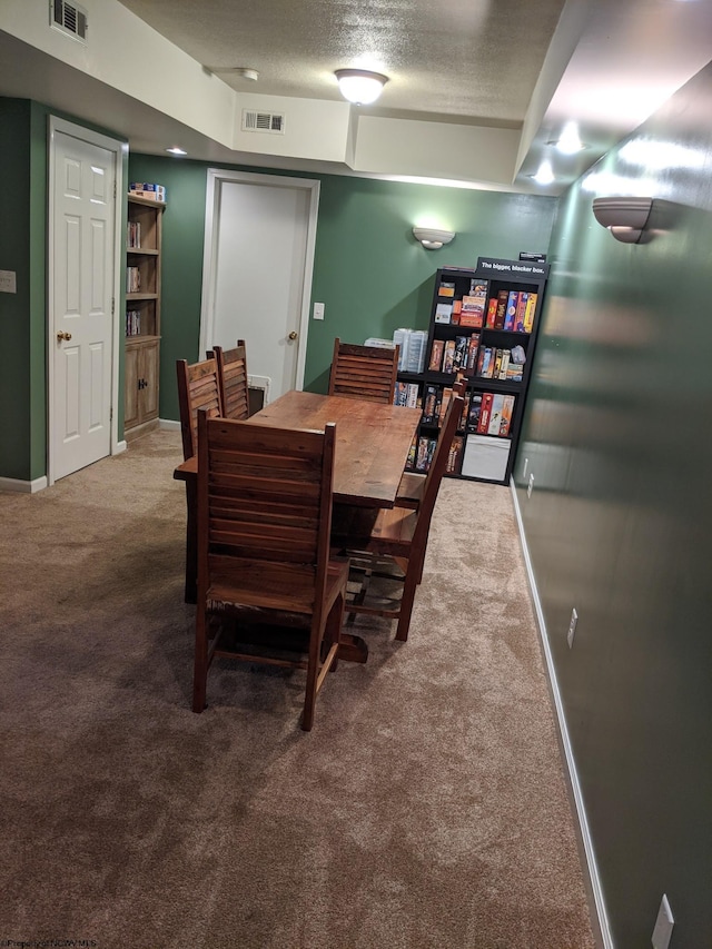 dining room featuring carpet floors and a textured ceiling