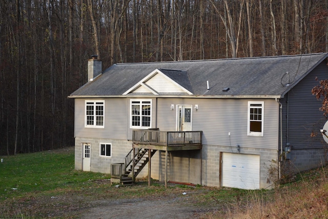 back of house featuring central AC unit, a deck, and a garage