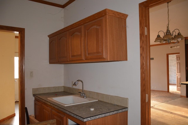 kitchen with sink, hanging light fixtures, and a notable chandelier