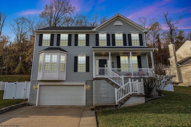 view of front of property with a porch, a garage, and a yard