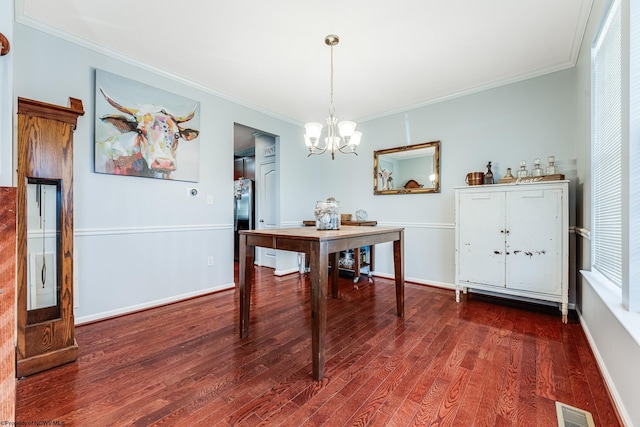 dining space featuring crown molding, dark hardwood / wood-style floors, and a chandelier