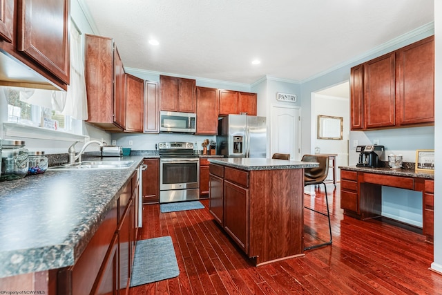 kitchen featuring dark wood-type flooring, a breakfast bar area, a center island, and appliances with stainless steel finishes