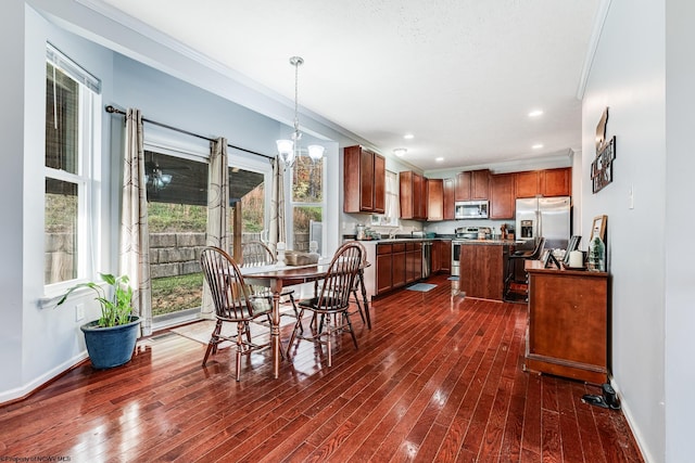 dining area with ornamental molding, sink, a notable chandelier, and dark hardwood / wood-style flooring