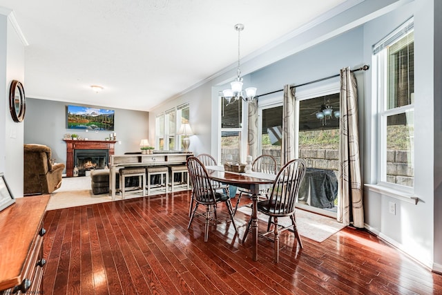 dining space featuring hardwood / wood-style floors, a notable chandelier, plenty of natural light, and ornamental molding