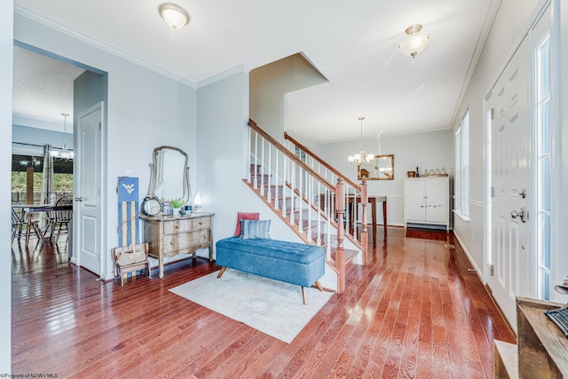 foyer with an inviting chandelier, crown molding, and hardwood / wood-style flooring