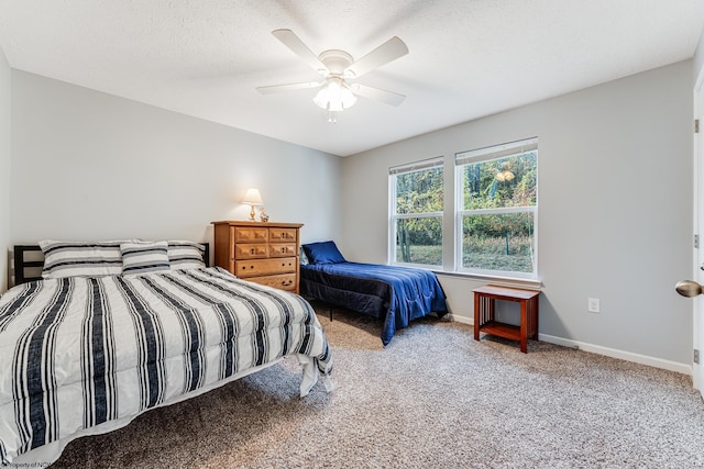 bedroom with ceiling fan, carpet, and a textured ceiling