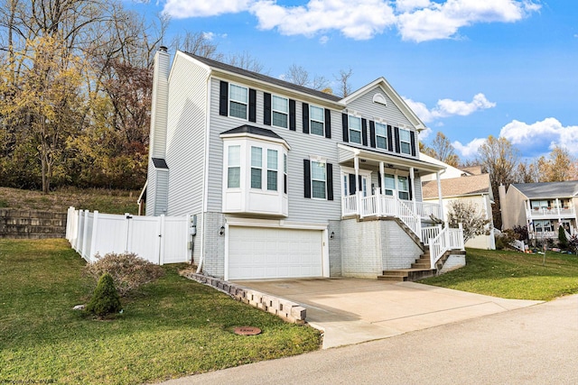 view of front of property featuring a garage, a front lawn, and a porch