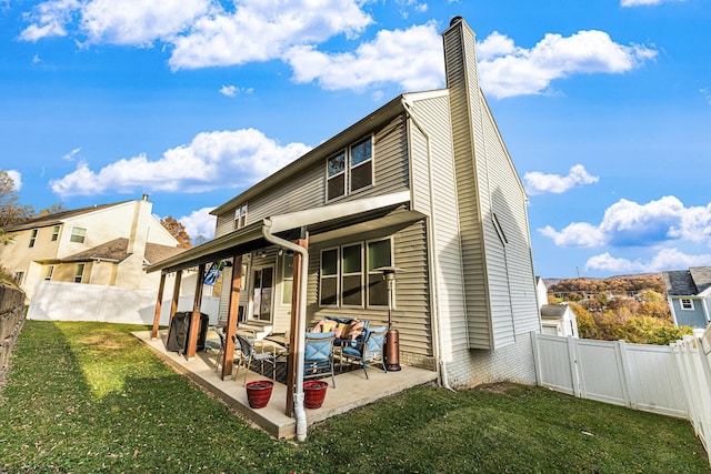 rear view of house featuring a patio area and a lawn