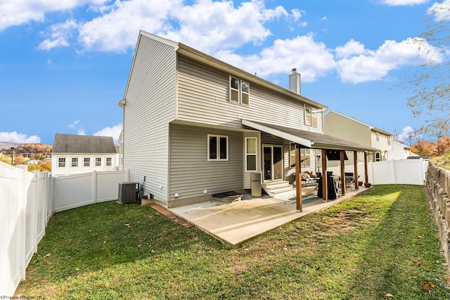 back of property with a yard, cooling unit, and a patio area