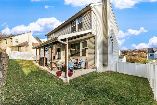 rear view of property featuring a yard and a patio