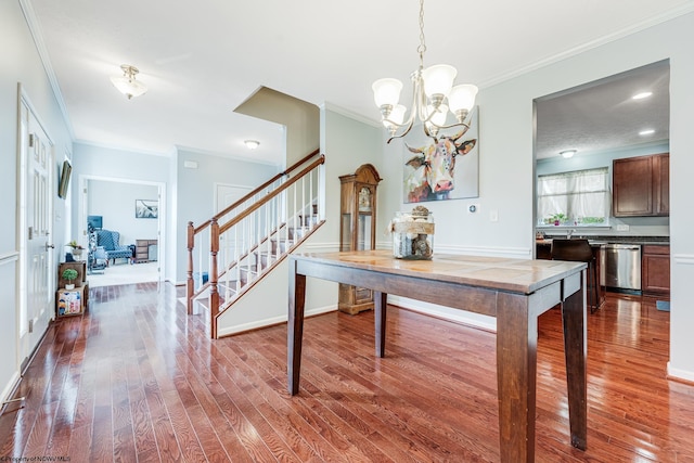 dining area featuring hardwood / wood-style floors, ornamental molding, and a chandelier