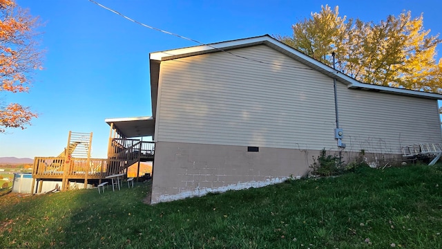 view of home's exterior featuring a deck and a yard