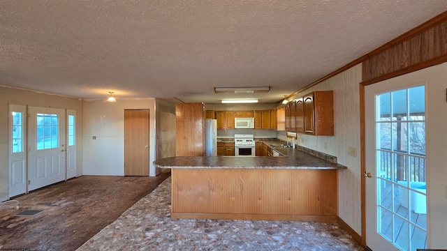 kitchen with kitchen peninsula, a textured ceiling, and white appliances