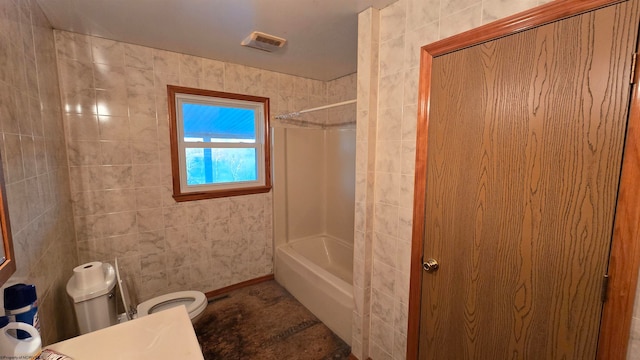 bathroom with shower / bathing tub combination, tile walls, and toilet