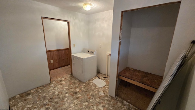 bathroom with wood walls and washer / clothes dryer