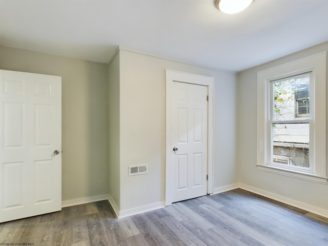 unfurnished bedroom with a closet and hardwood / wood-style floors