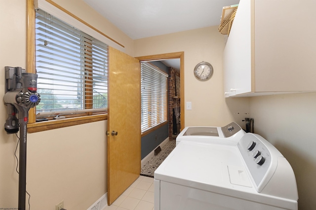 laundry area featuring cabinets, washing machine and dryer, and light tile patterned flooring