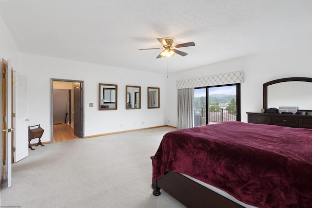 carpeted bedroom with access to exterior, a textured ceiling, and ceiling fan