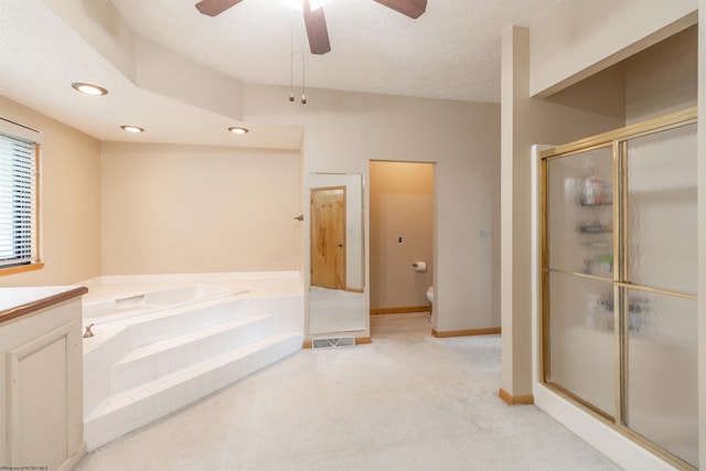 full bathroom with ceiling fan, separate shower and tub, a textured ceiling, toilet, and vanity