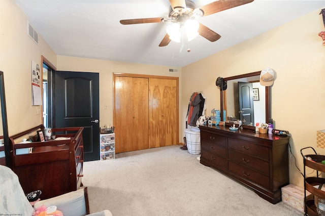 bedroom featuring ceiling fan, a closet, and light carpet