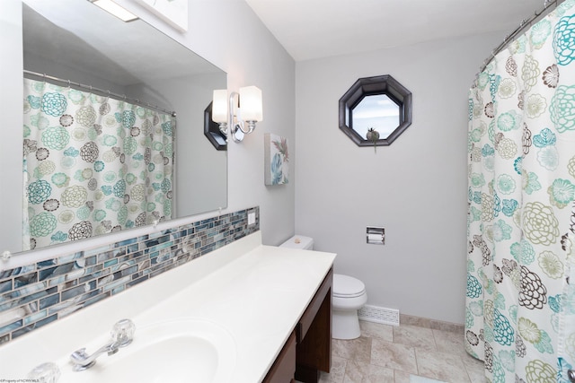 bathroom with decorative backsplash, vanity, toilet, and walk in shower