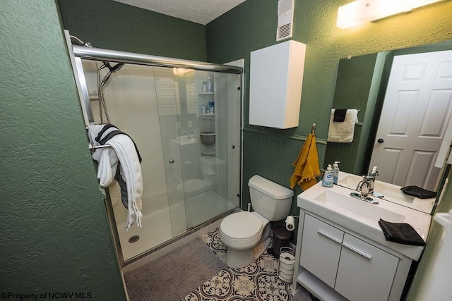 bathroom with toilet, vanity, a textured ceiling, and walk in shower