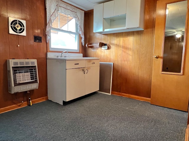 kitchen with heating unit, wood walls, and ceiling fan