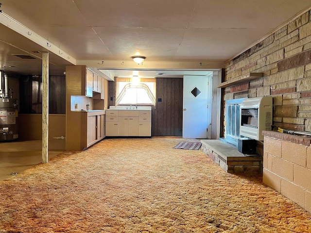 kitchen with gas water heater, heating unit, and light colored carpet