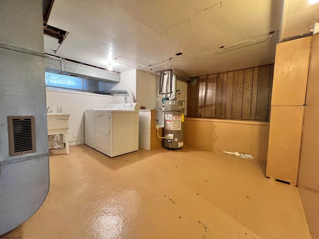 basement featuring sink, washer and dryer, and gas water heater