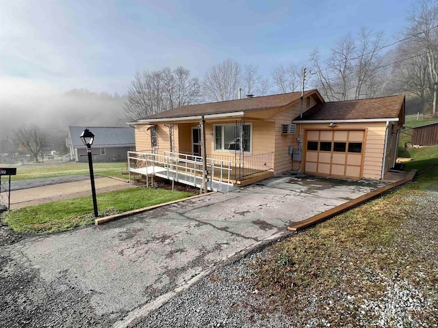 ranch-style home with covered porch, a garage, and a front lawn