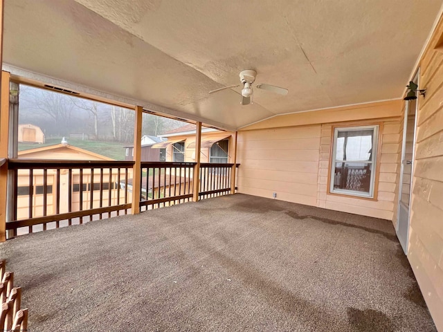 unfurnished sunroom with ceiling fan and vaulted ceiling