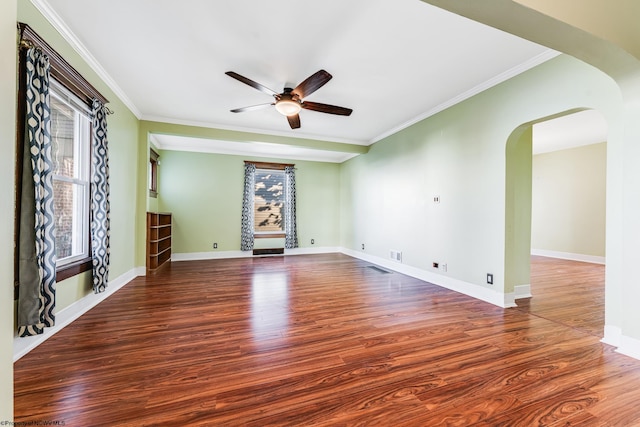 empty room with ornamental molding, ceiling fan, and dark wood-type flooring