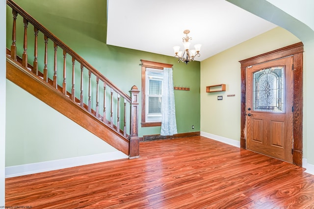 foyer entrance featuring a notable chandelier, a healthy amount of sunlight, and light wood-type flooring