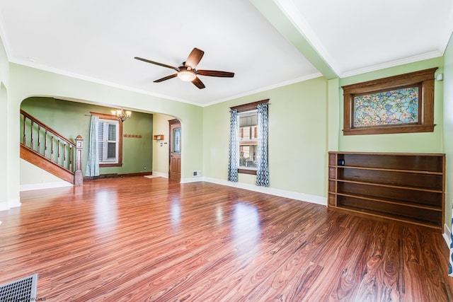 unfurnished living room with crown molding, wood-type flooring, and ceiling fan with notable chandelier