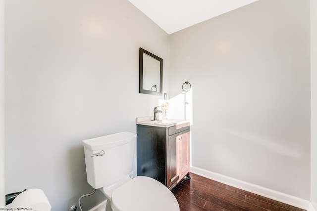 bathroom with hardwood / wood-style flooring, vanity, and toilet