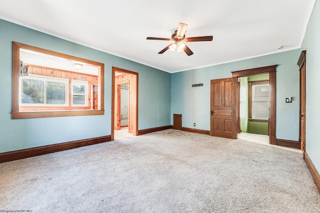 unfurnished bedroom with ceiling fan, crown molding, and light carpet