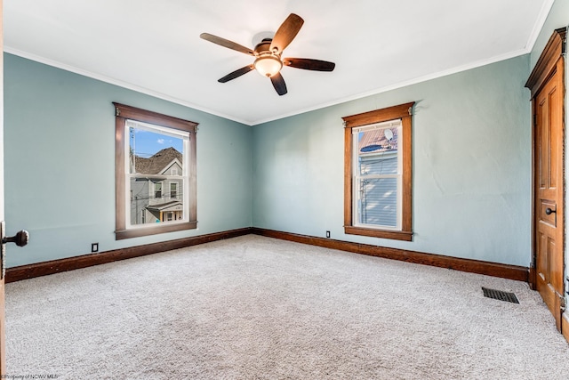 carpeted empty room with ceiling fan and ornamental molding