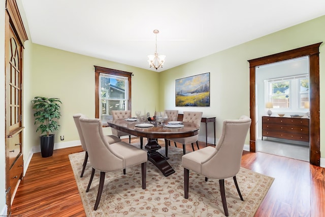 dining area featuring a wealth of natural light, an inviting chandelier, and light hardwood / wood-style flooring