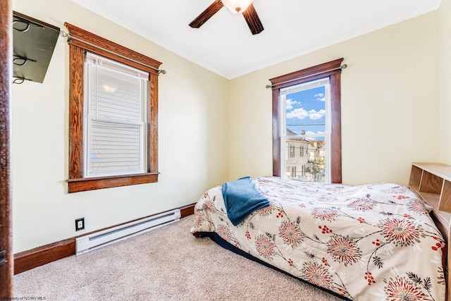 carpeted bedroom featuring ceiling fan, crown molding, and a baseboard heating unit