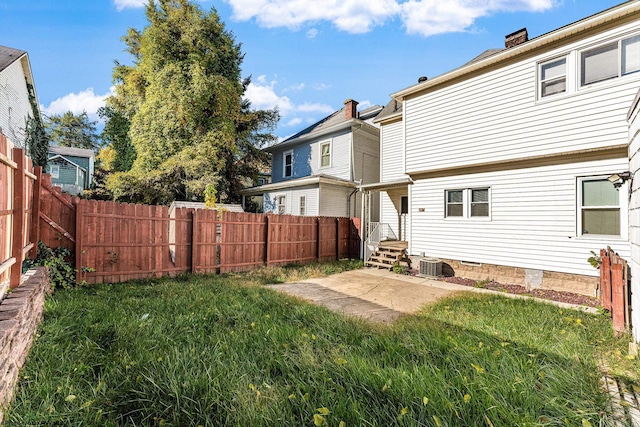 back of property with a lawn, a patio area, and cooling unit