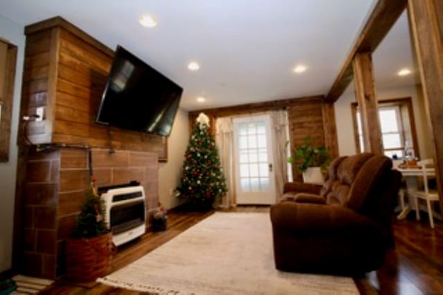 living room with a fireplace, plenty of natural light, hardwood / wood-style floors, and heating unit