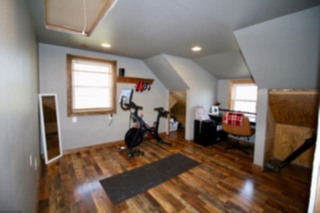 exercise area with a wealth of natural light, dark wood-type flooring, and lofted ceiling